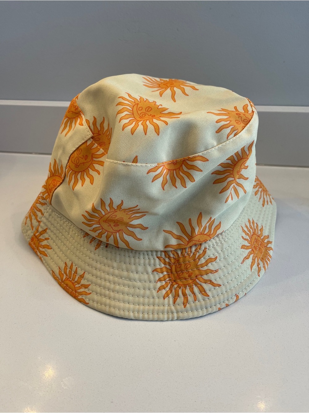 Tan and orange sun graphic bucket hat